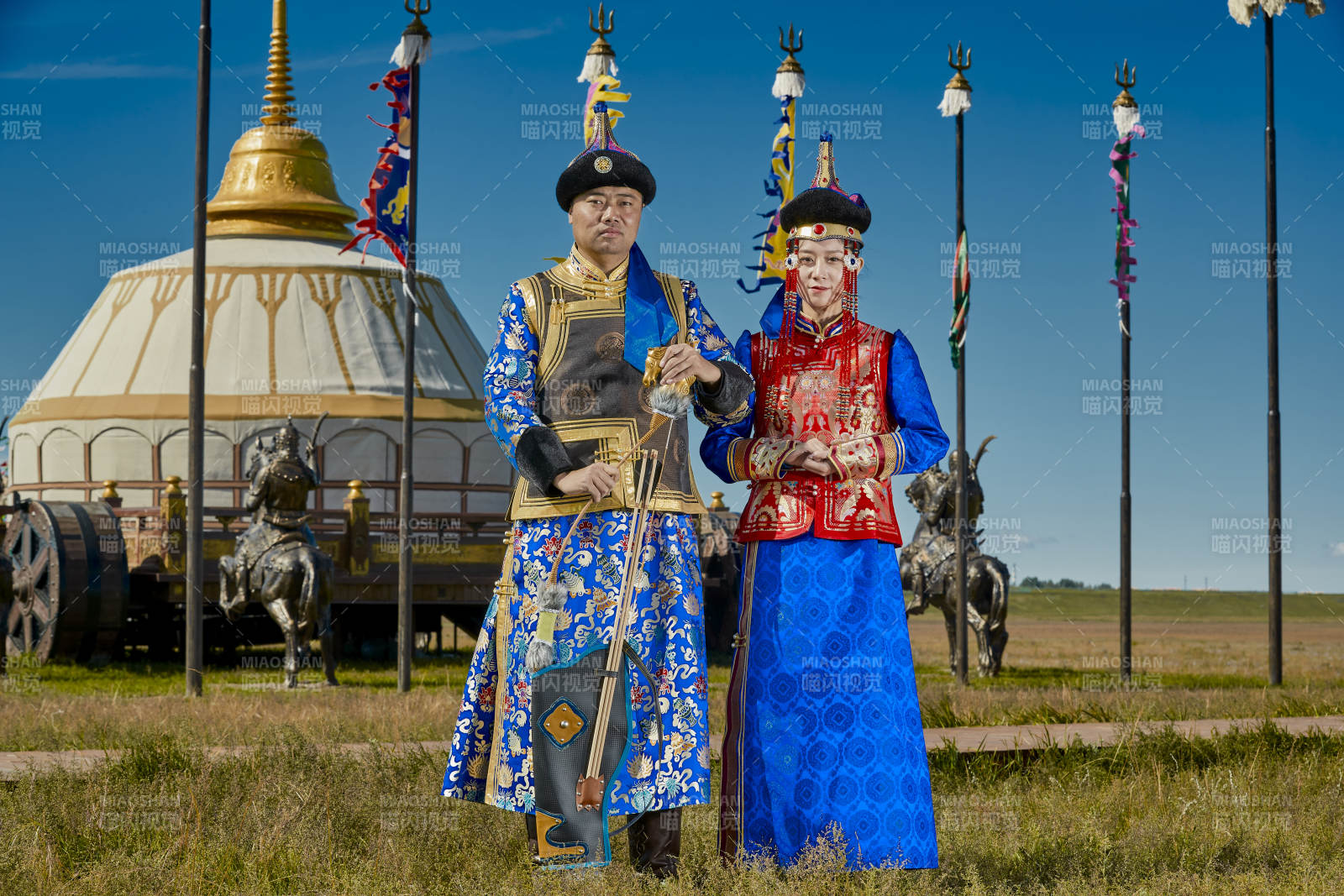 草原上蒙古包前穿蒙古族传统服饰的年轻夫妻图片