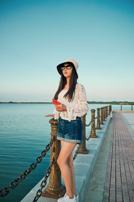 盛夏夕阳晚霞湖边码头看风景的少女图片