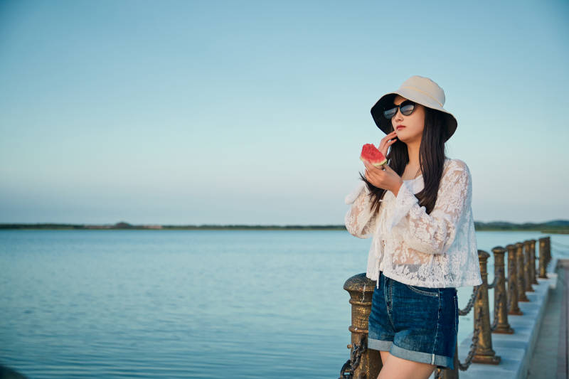 盛夏夕阳晚霞湖边码头看风景的少女图片