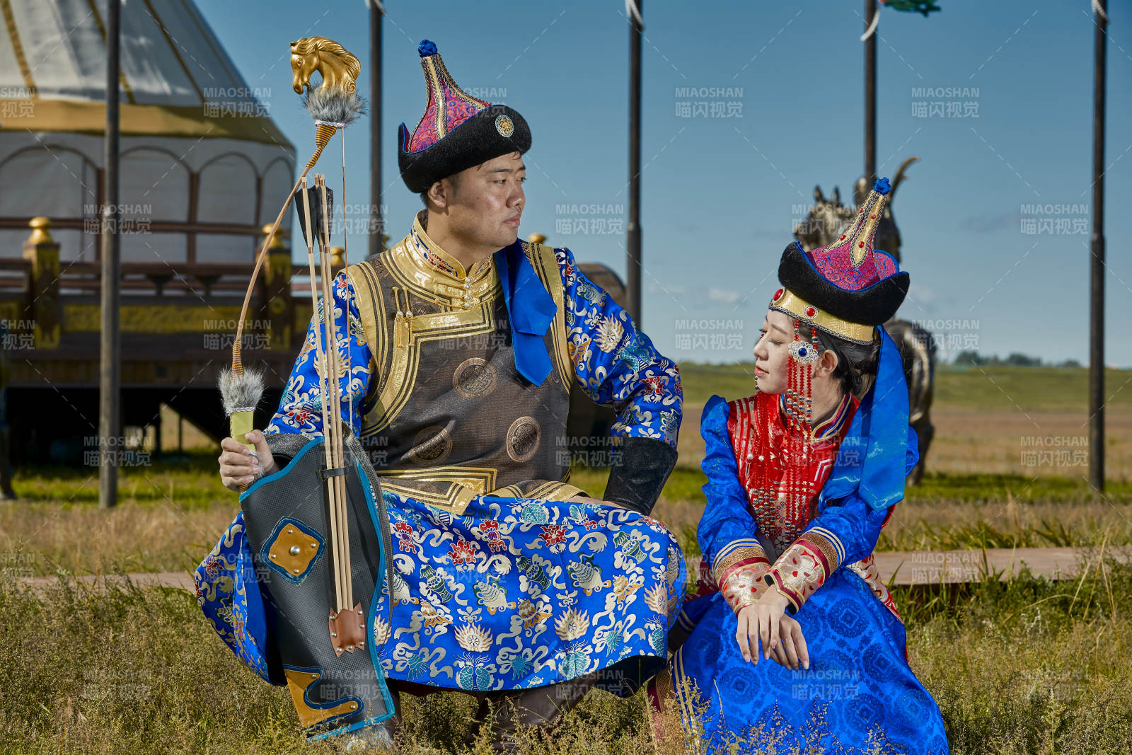 草原上蒙古包前穿蒙古族传统服饰的年轻夫妻图片