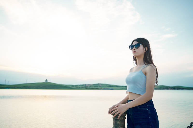 盛夏夕阳晚霞湖边码头看风景的少女图片