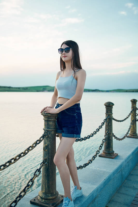 盛夏夕阳晚霞湖边码头看风景的少女图片