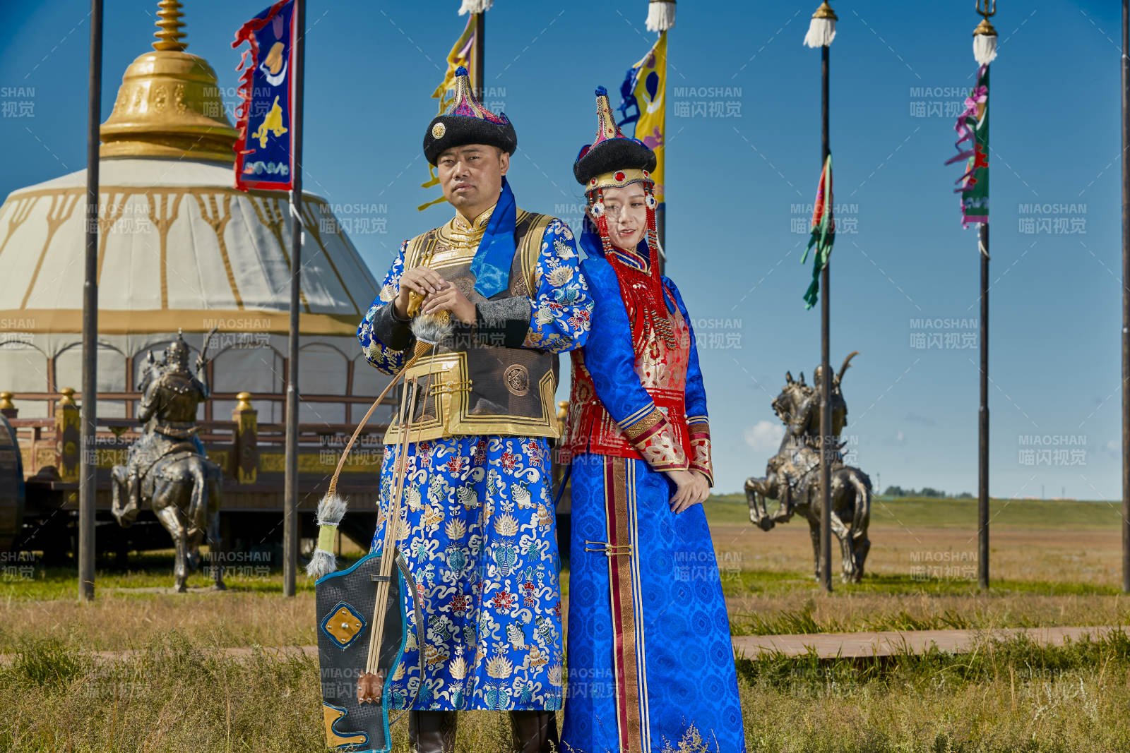 草原上蒙古包前穿蒙古族传统服饰的年轻夫妻图片