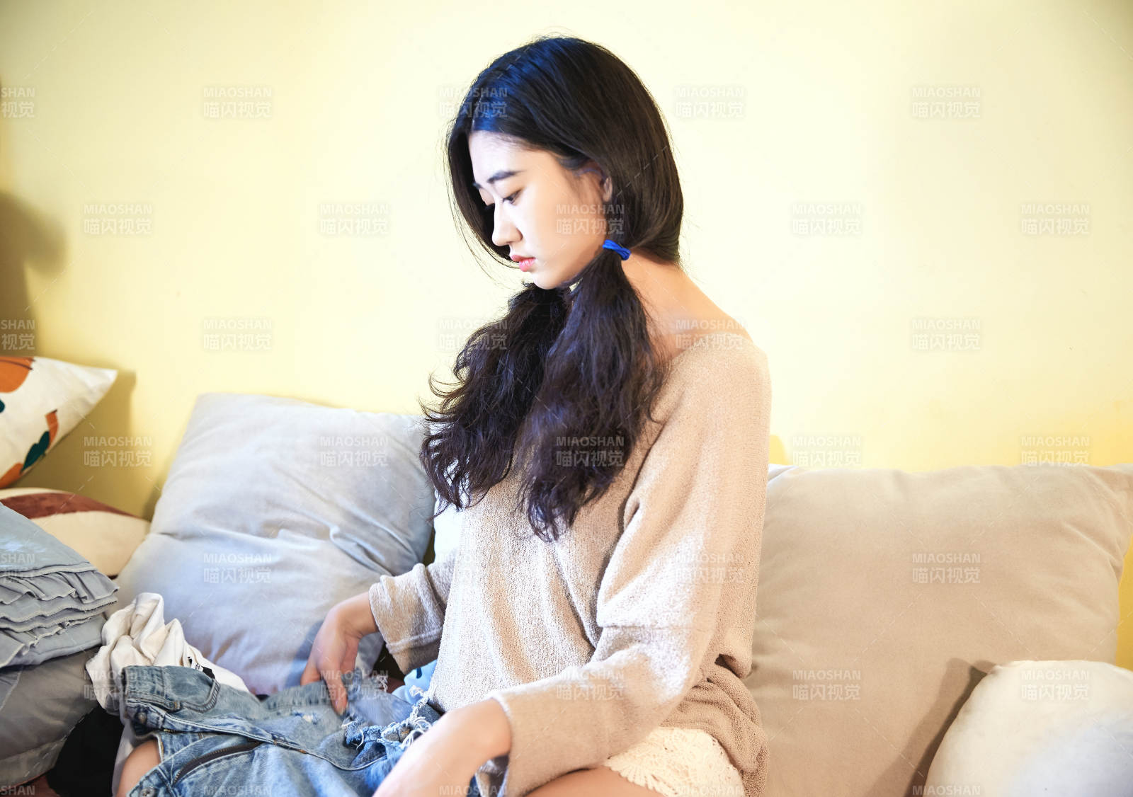 在沙发床上整理行装的年轻亚洲女性图片