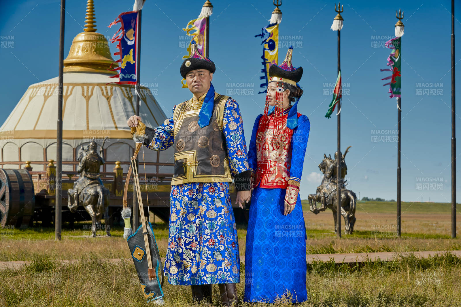 草原上蒙古包前穿蒙古族传统服饰的年轻夫妻图片