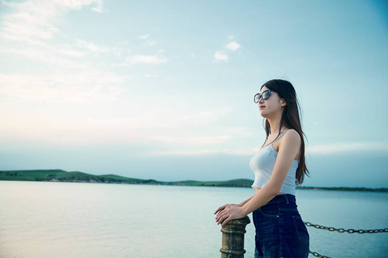 盛夏夕阳晚霞湖边码头看风景的少女图片
