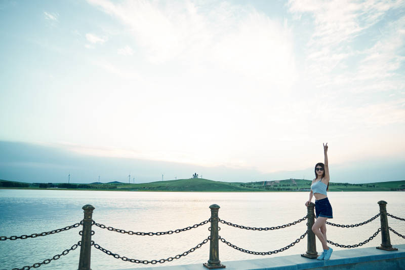 盛夏夕阳晚霞湖边码头看风景的少女图片