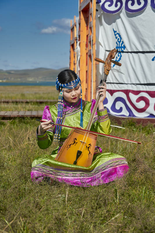 蒙古包前穿蒙古族服饰拉马头琴的蒙族女乐手图片