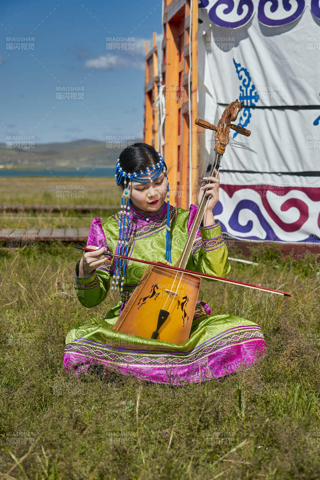 蒙古包前穿蒙古族服饰拉马头琴的蒙族女乐手图片