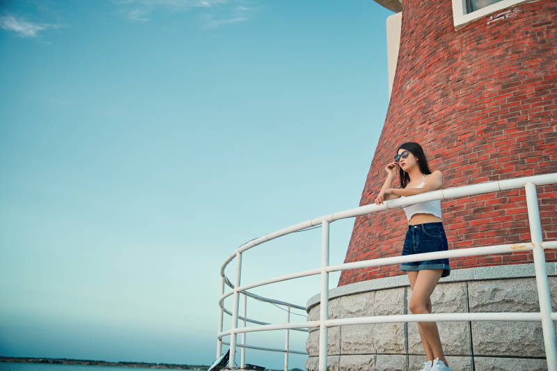 盛夏夕阳晚霞湖边码头看风景的少女图片