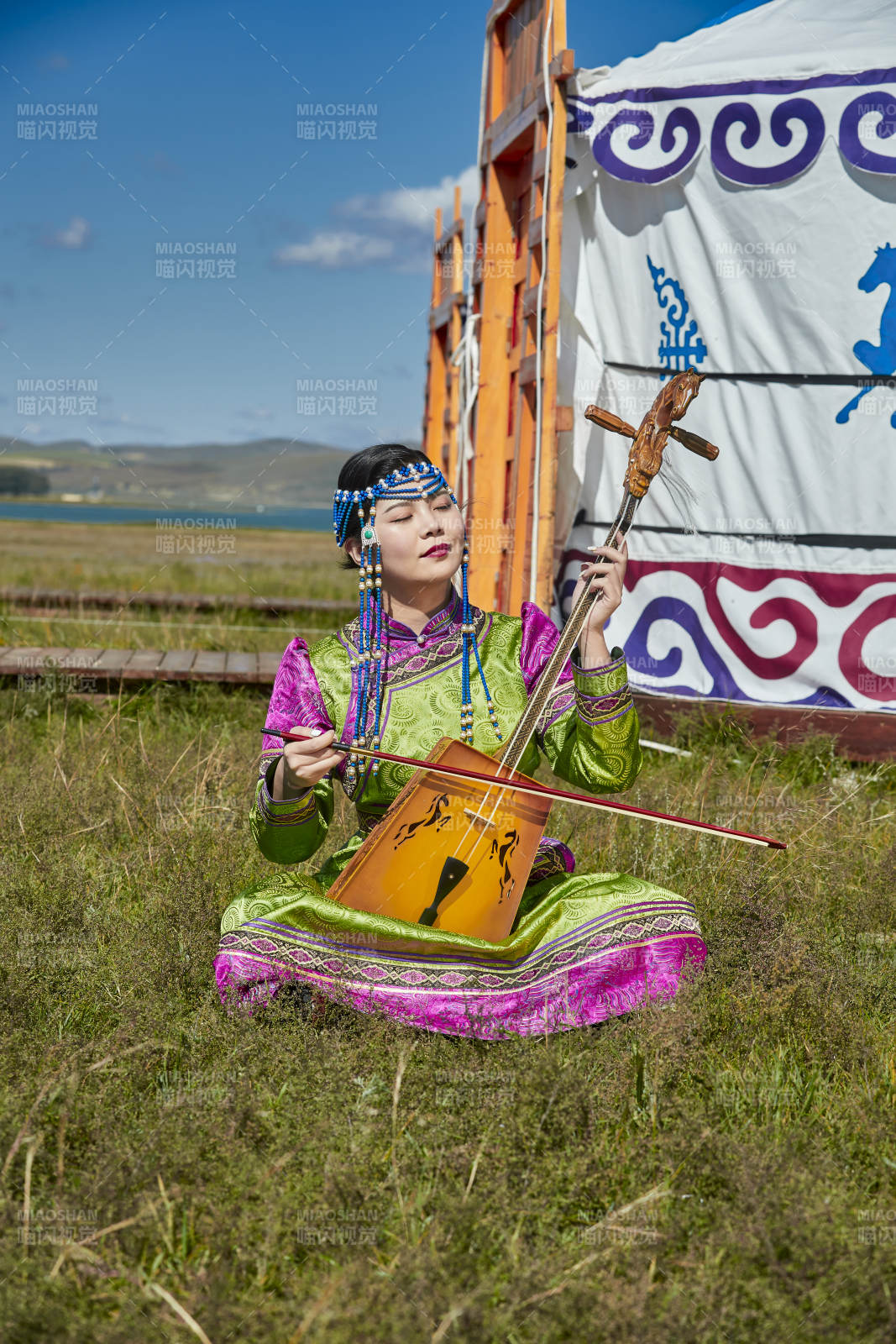 蒙古包前穿蒙古族服饰拉马头琴的蒙族女乐手图片