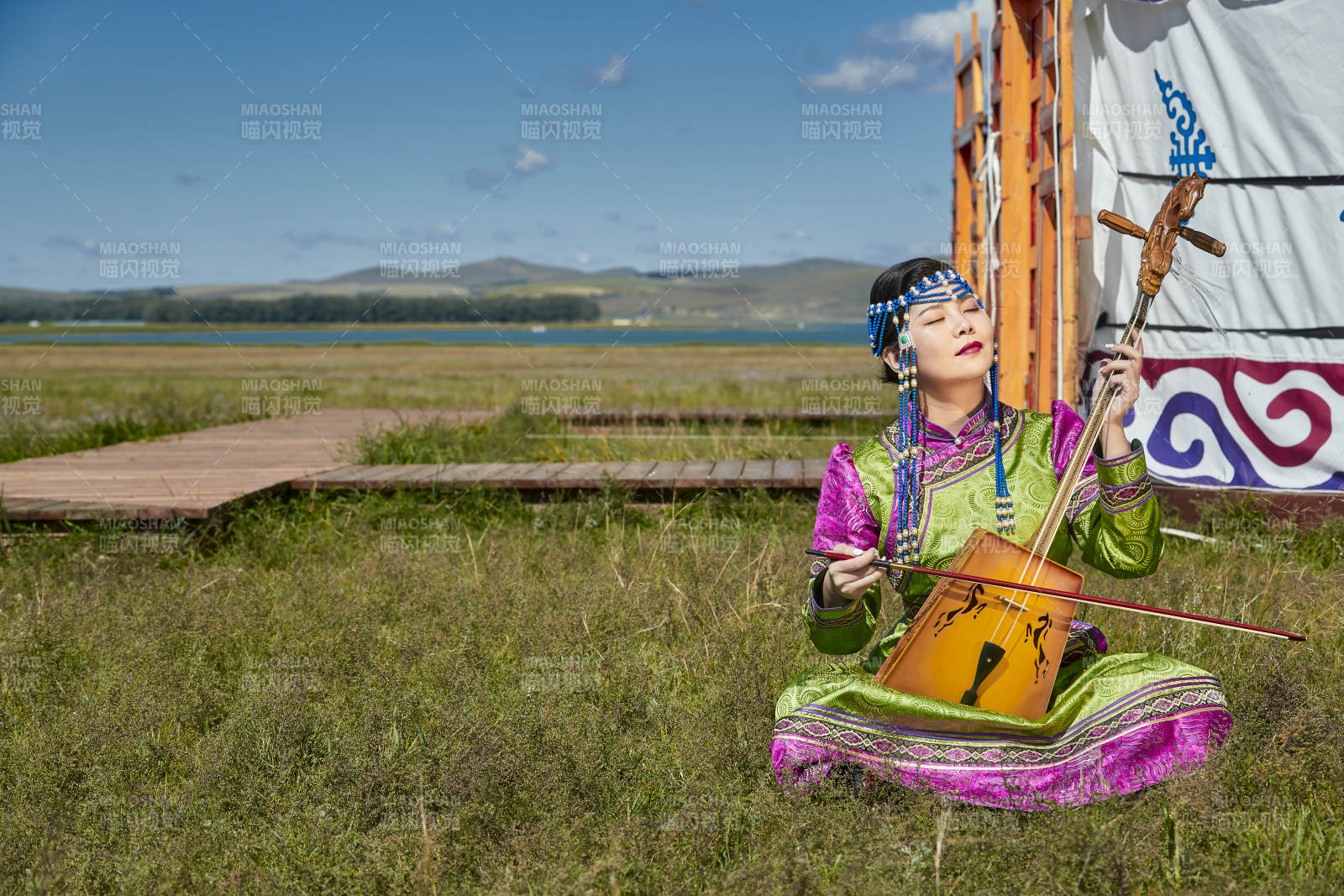 蒙古包前穿蒙古族服饰拉马头琴的蒙族女乐手图片