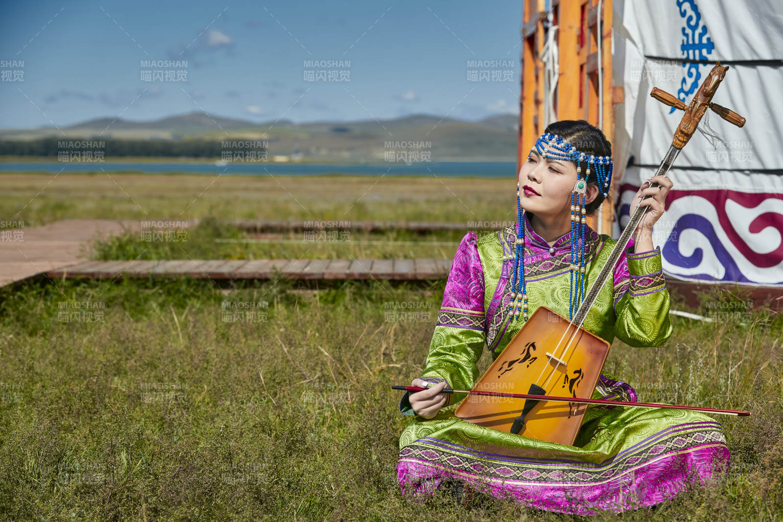蒙古包前穿蒙古族服饰拉马头琴的蒙族女乐手图片
