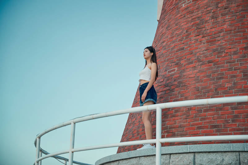 盛夏夕阳晚霞湖边码头看风景的少女图片