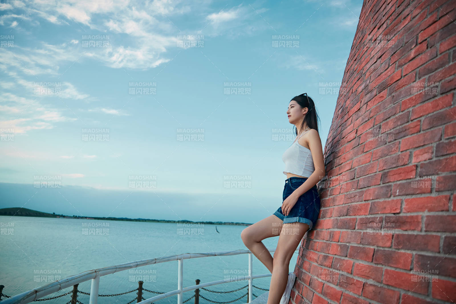 盛夏夕阳晚霞湖边码头看风景的少女图片