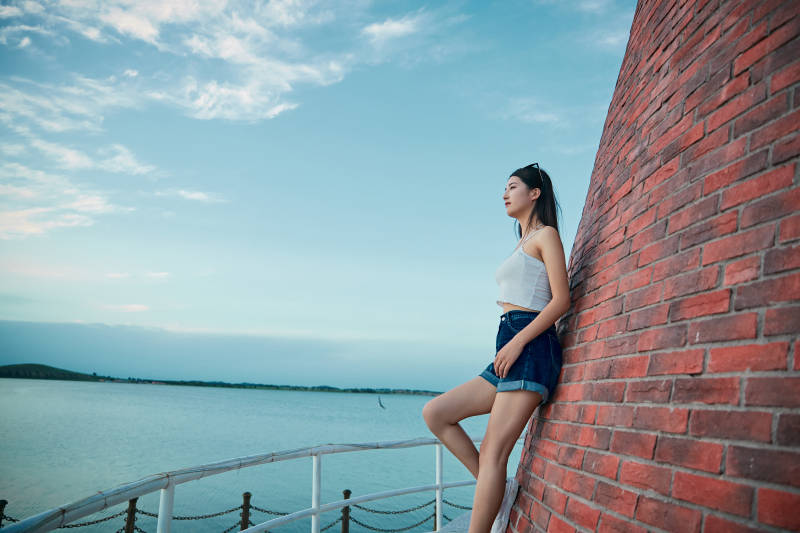 盛夏夕阳晚霞湖边码头看风景的少女图片