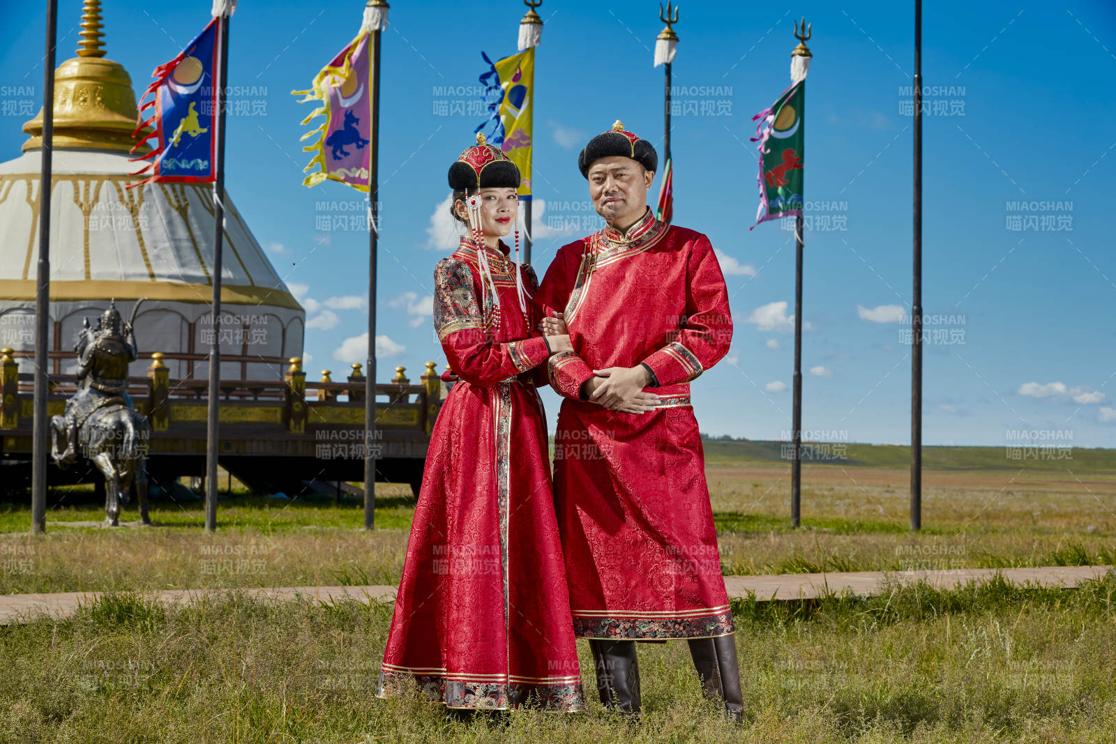 草原上蒙古包前穿蒙古族传统服饰的年轻夫妻图片