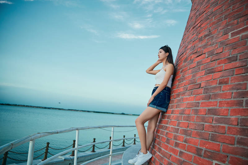 盛夏夕阳晚霞湖边码头看风景的少女图片