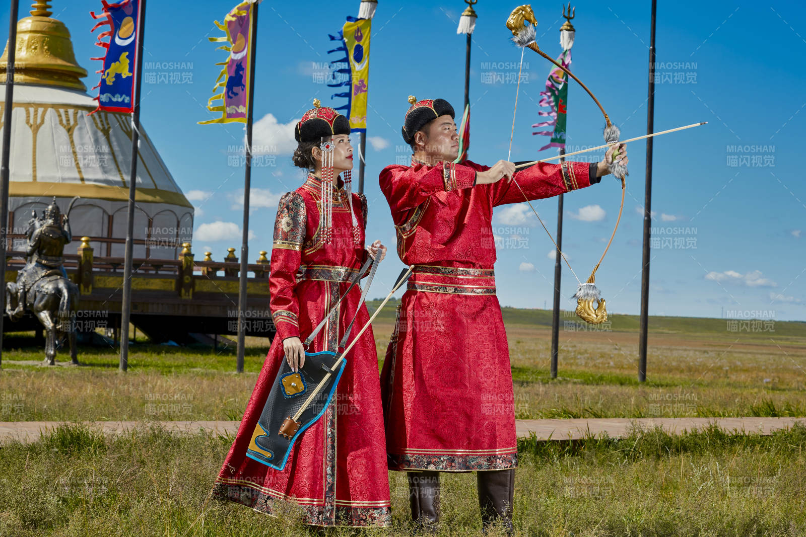 草原上蒙古包前穿蒙古族传统服饰的年轻夫妻图片