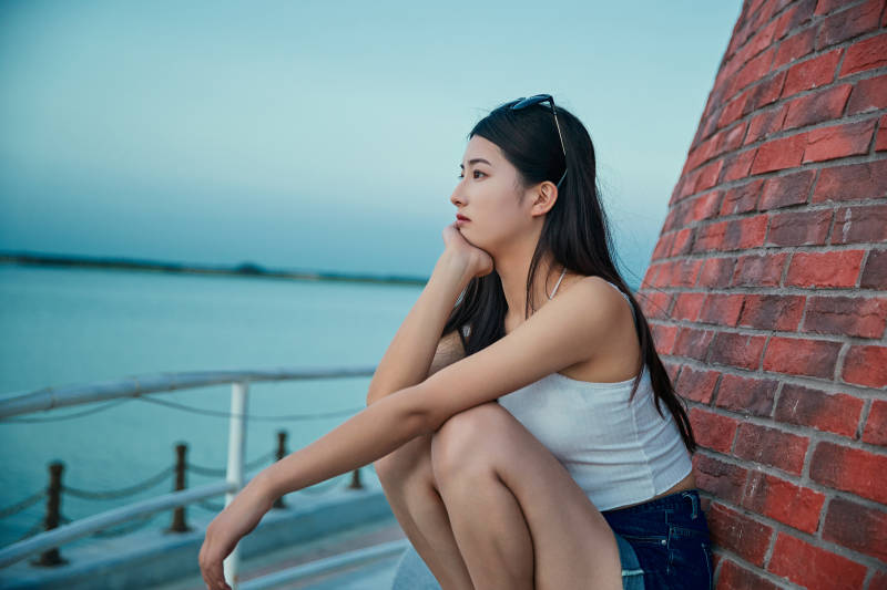 盛夏夕阳晚霞湖边码头看风景的少女图片