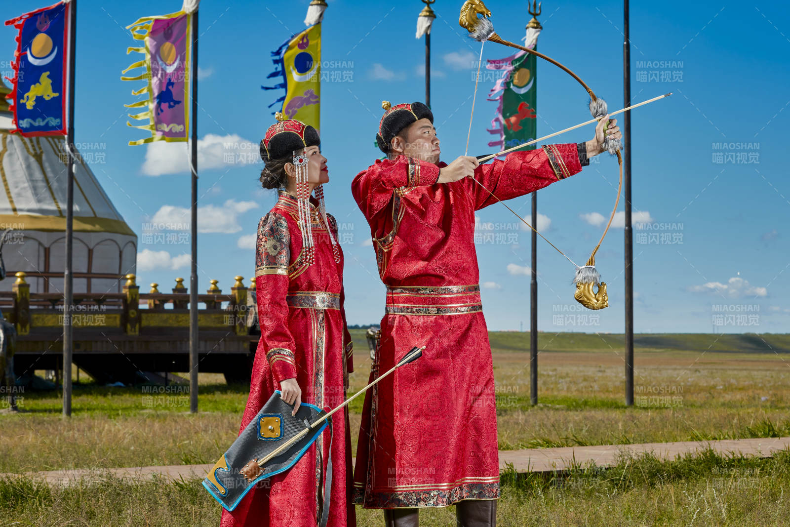 草原上蒙古包前穿蒙古族传统服饰的年轻夫妻图片