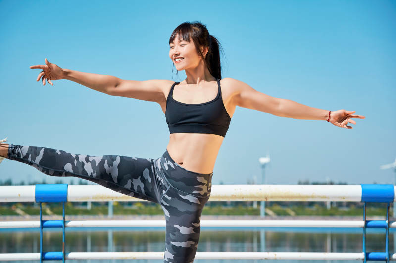 户外河畔公园做拉伸有氧运动的亚洲女性图片