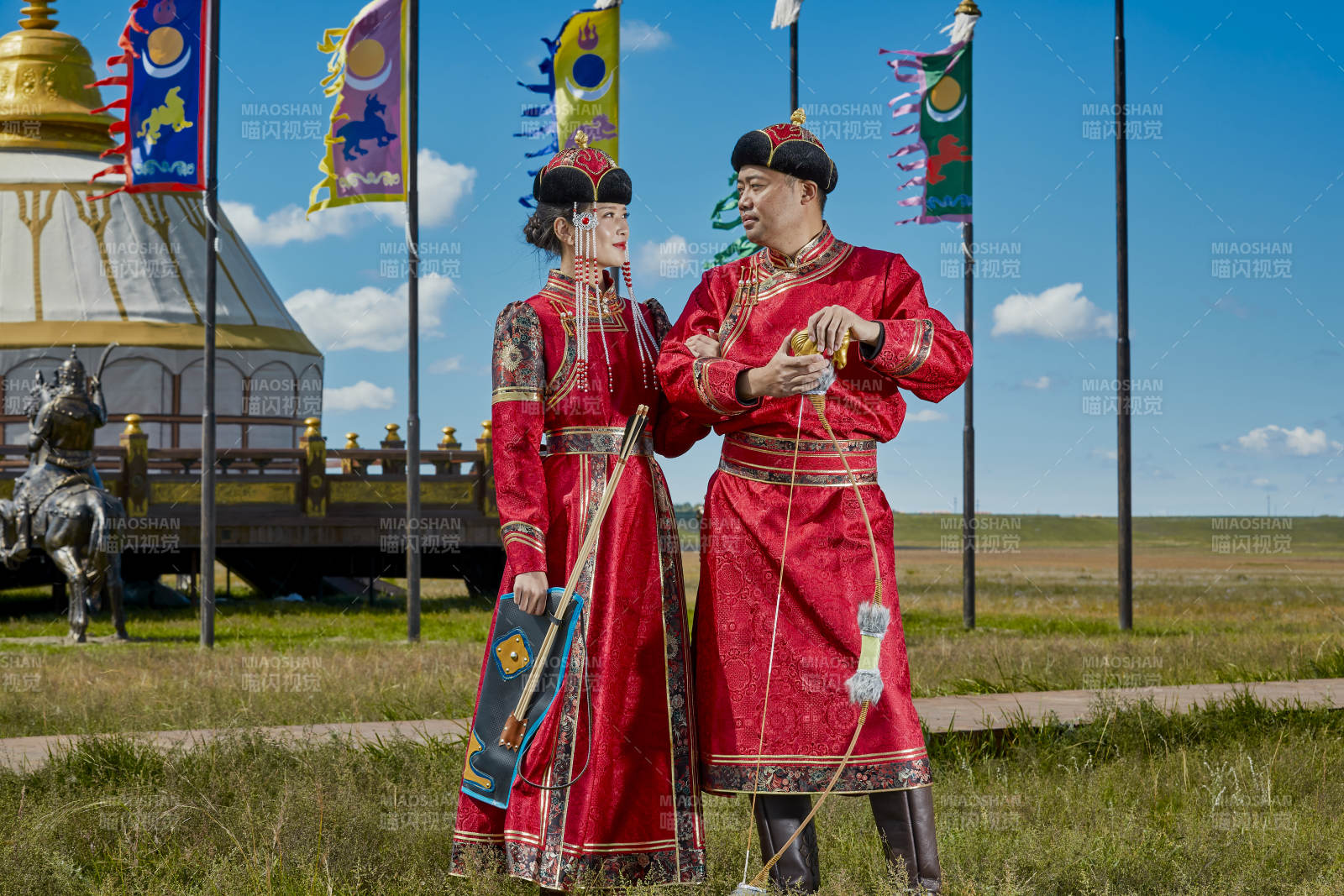 草原上蒙古包前穿蒙古族传统服饰的年轻夫妻图片