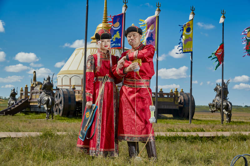 草原上蒙古包前穿蒙古族传统服饰的年轻夫妻图片