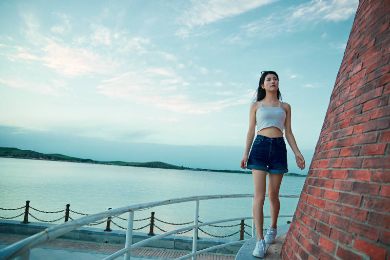 盛夏夕阳晚霞湖边码头看风景的少女图片