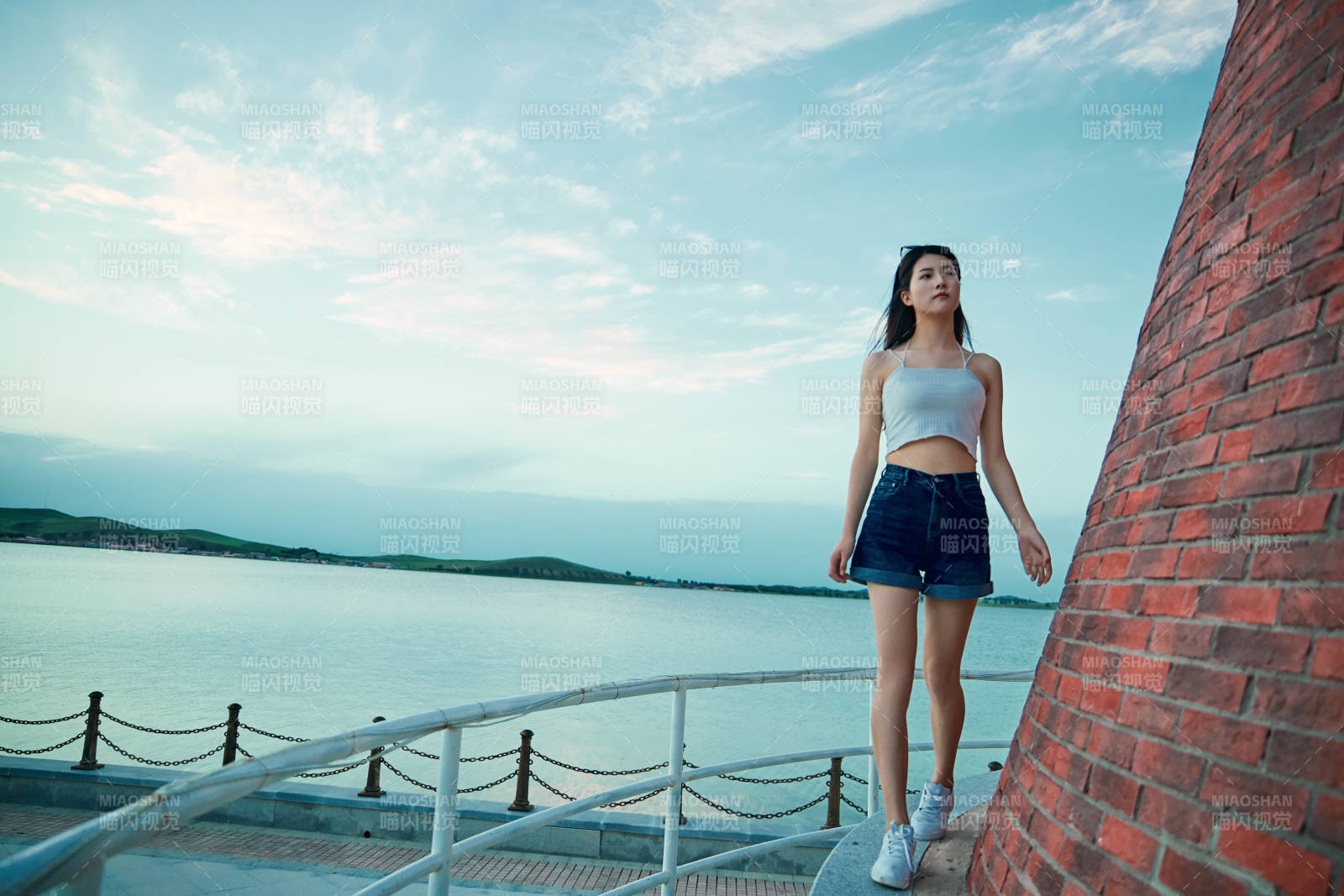 盛夏夕阳晚霞湖边码头看风景的少女图片