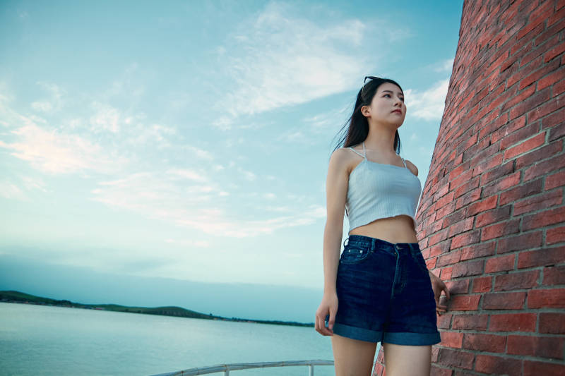 盛夏夕阳晚霞湖边码头看风景的少女图片