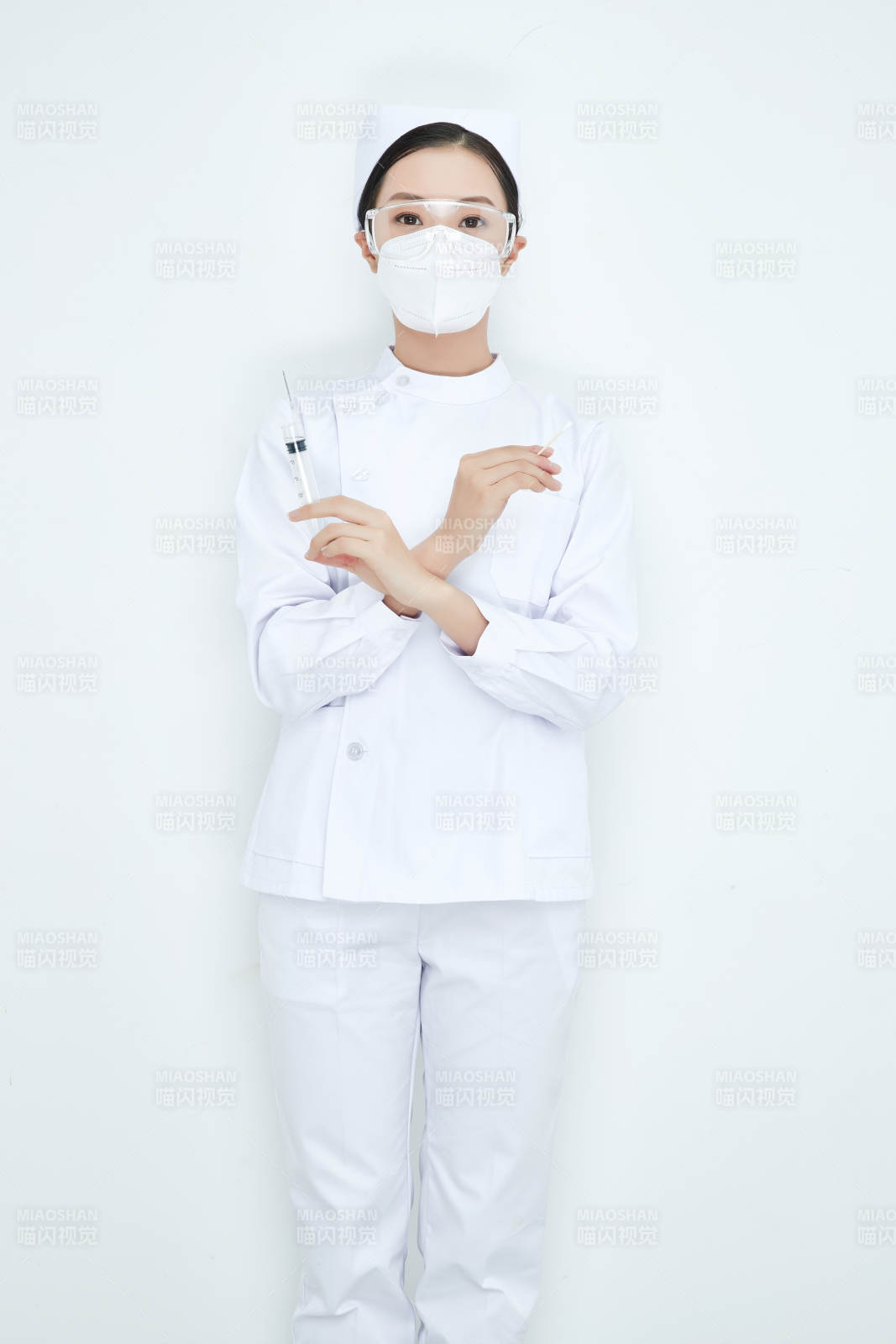 穿护士服戴口罩手执针筒的年轻女护士图片