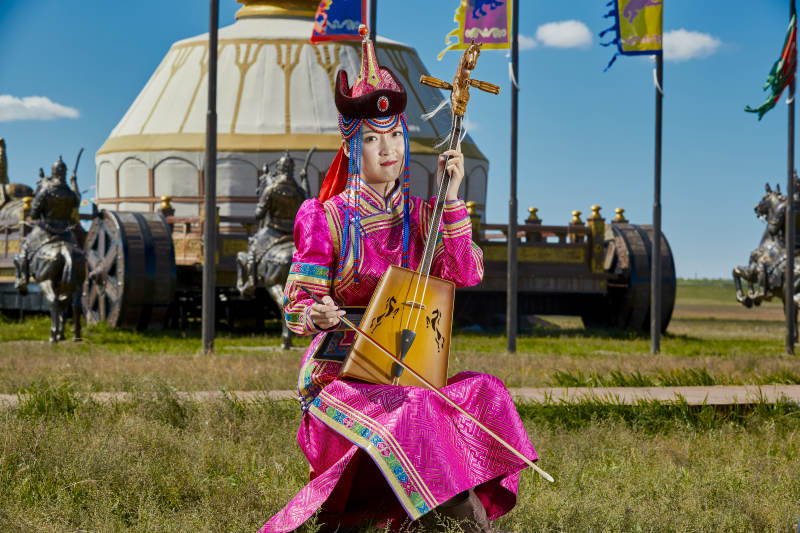 蒙古包前穿蒙古族服饰拉马头琴的蒙族女乐手图片