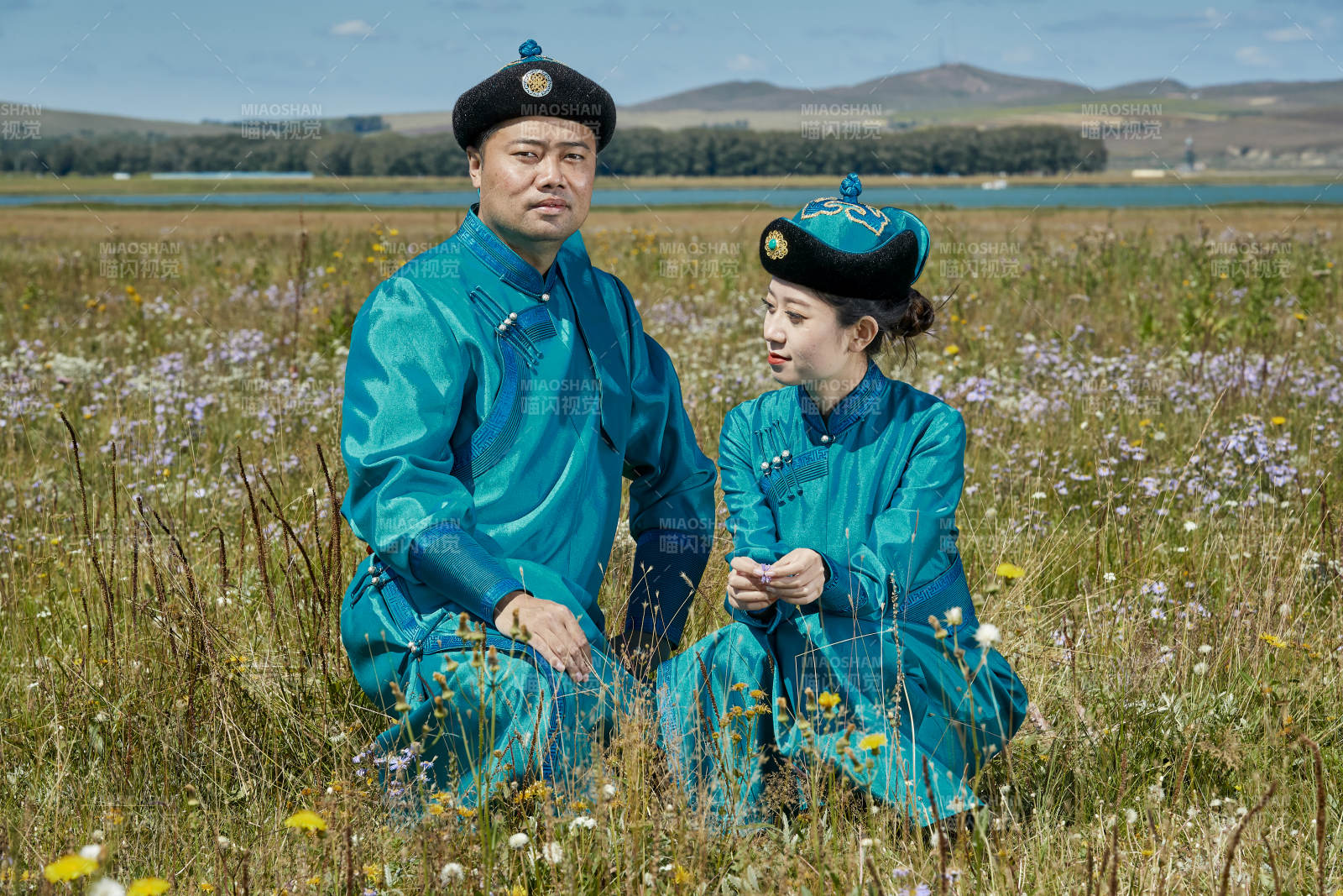 草原上蒙古包前穿蒙古族传统服饰的年轻夫妻图片