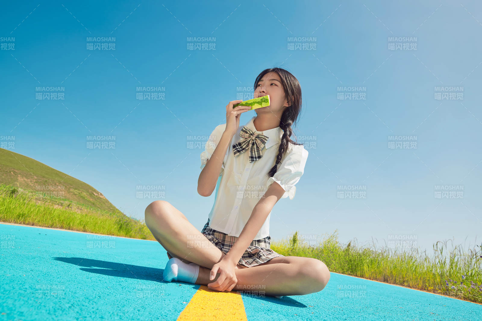 夏日户外湖边彩色公路上玩耍吃西瓜的少女图片