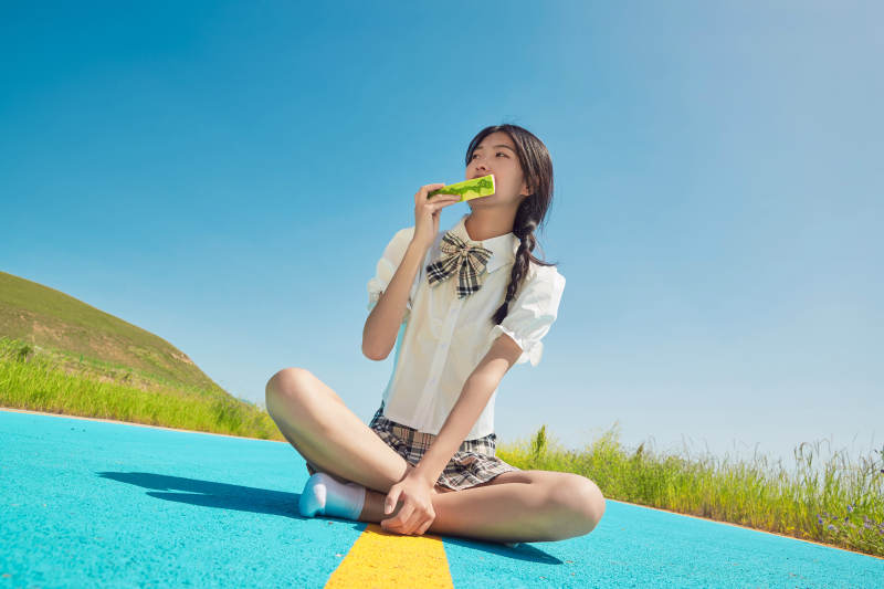 夏日户外湖边彩色公路上玩耍吃西瓜的少女图片