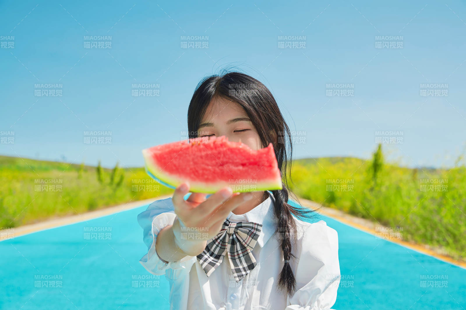 夏日户外湖边彩色公路上玩耍吃西瓜的少女图片