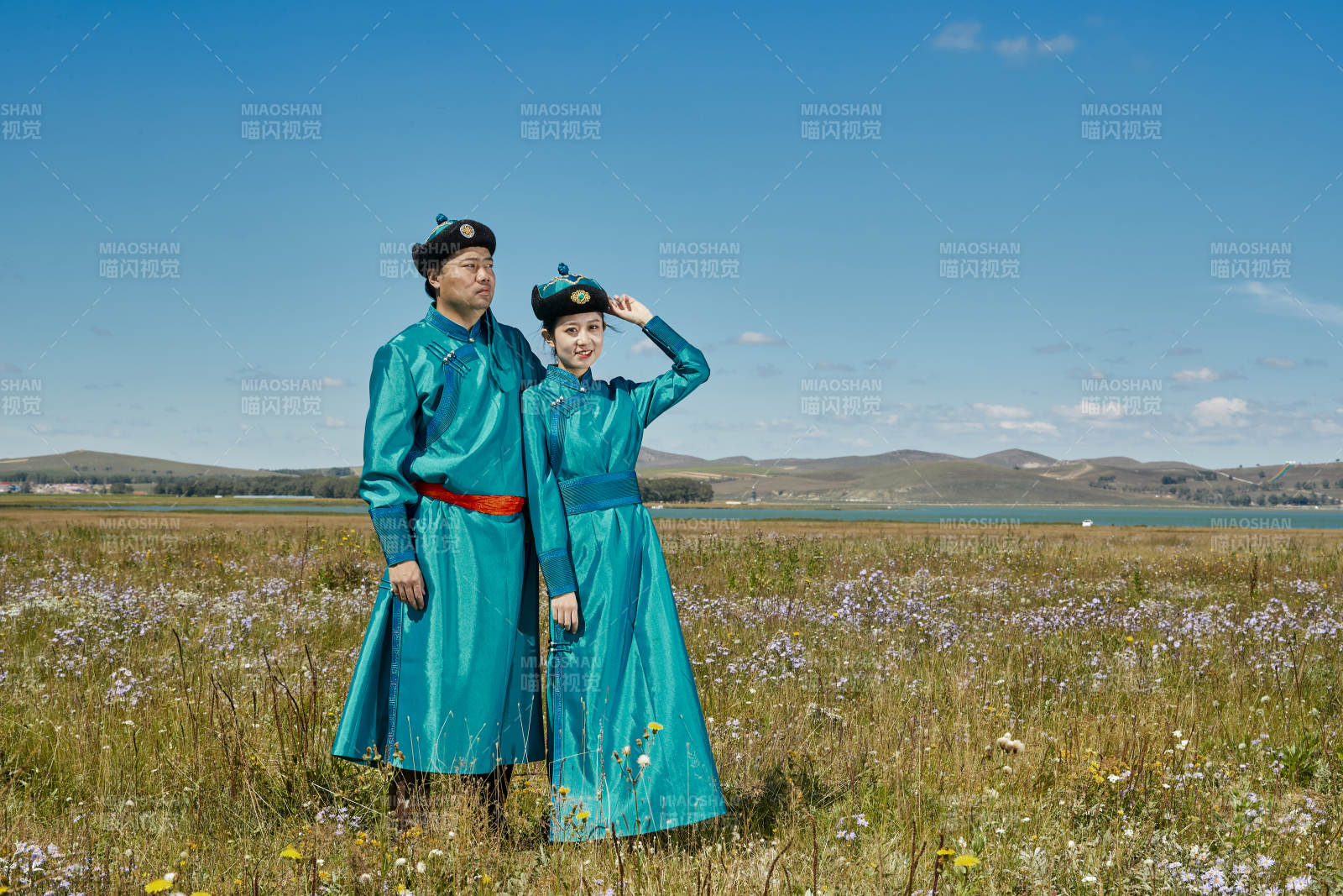 草原上蒙古包前穿蒙古族传统服饰的年轻夫妻图片