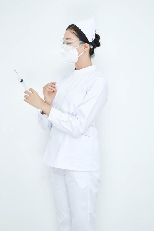 穿护士服戴口罩手执针筒的年轻女护士图片