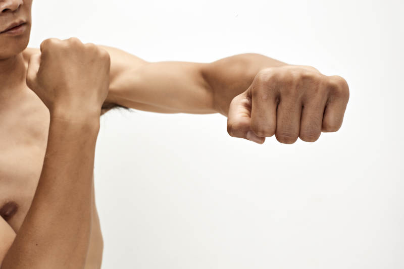 白色背景下演示自由搏击动作的亚洲功夫男性图片