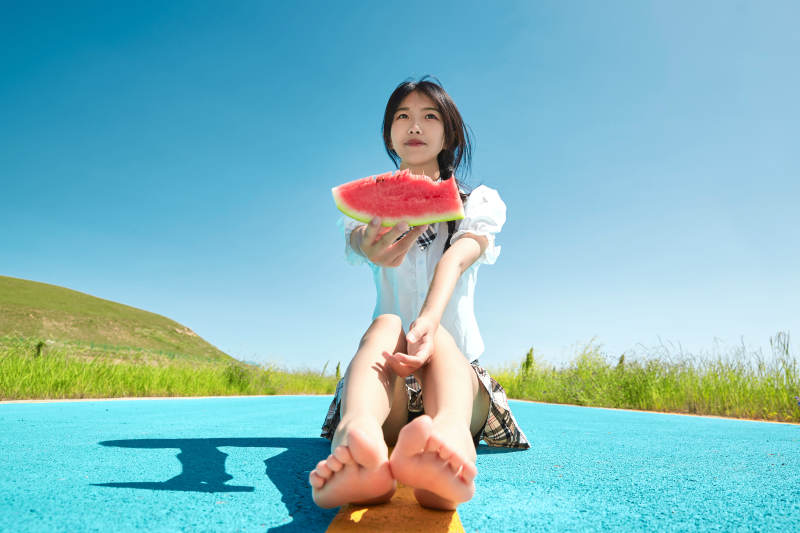 夏日户外湖边彩色公路上玩耍吃西瓜的少女图片