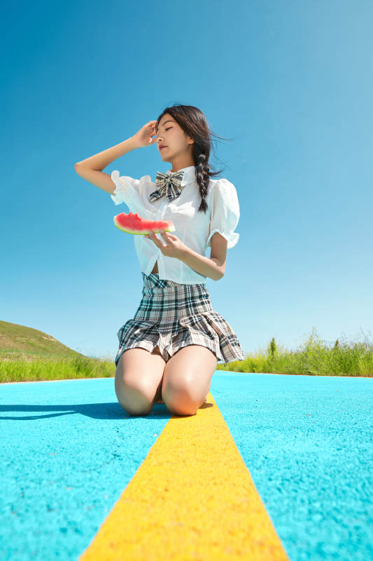 夏日户外湖边彩色公路上玩耍吃西瓜的少女图片