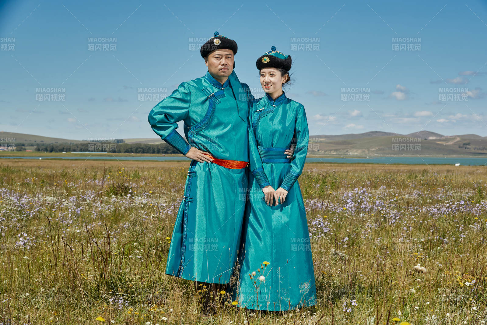 草原上蒙古包前穿蒙古族传统服饰的年轻夫妻图片