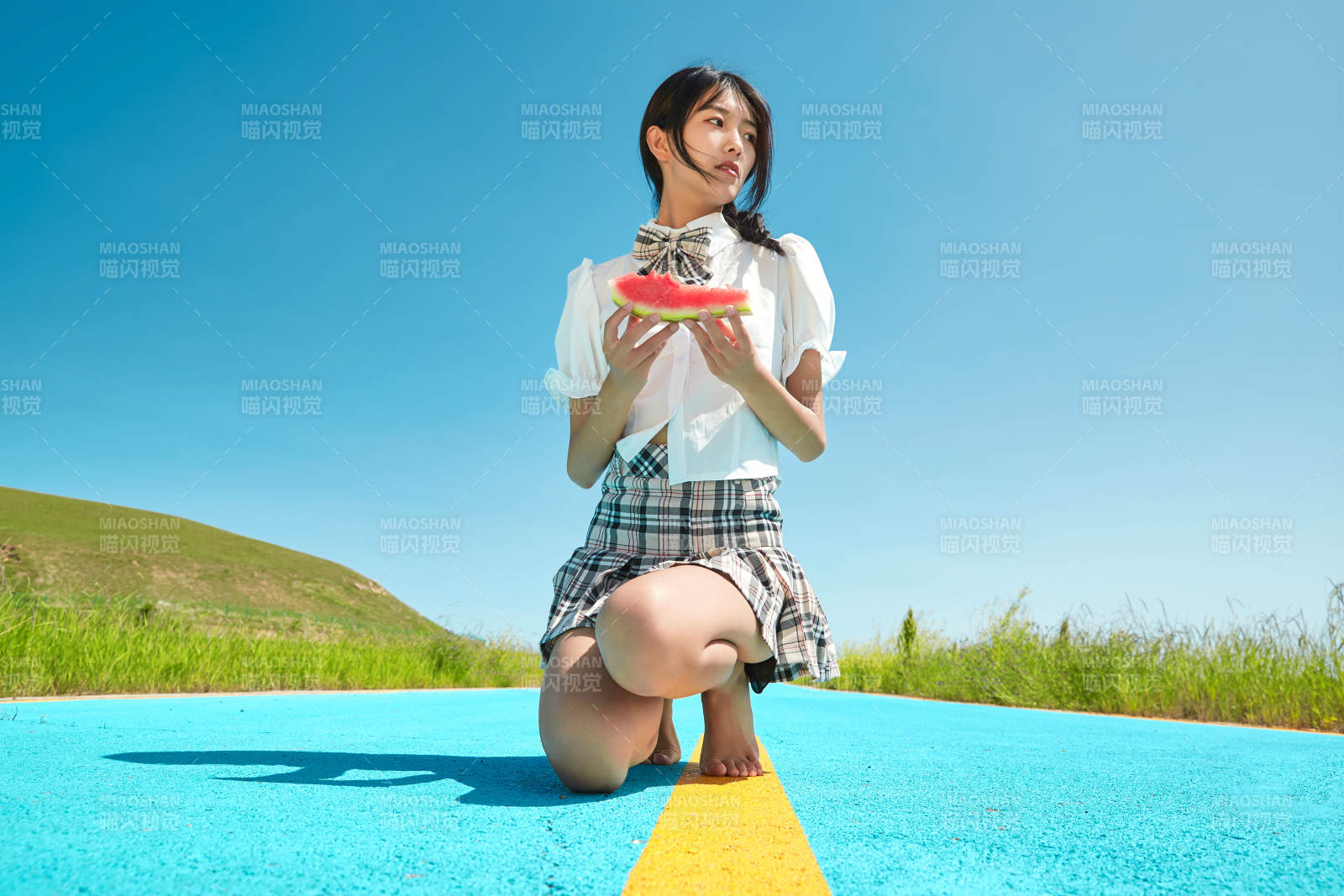 夏日户外湖边彩色公路上玩耍吃西瓜的少女图片