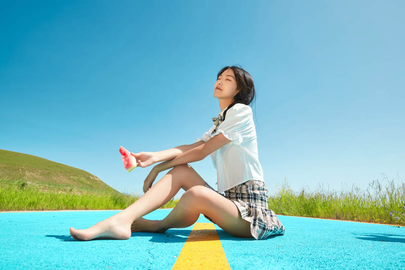 夏日户外湖边彩色公路上玩耍吃西瓜的少女图片