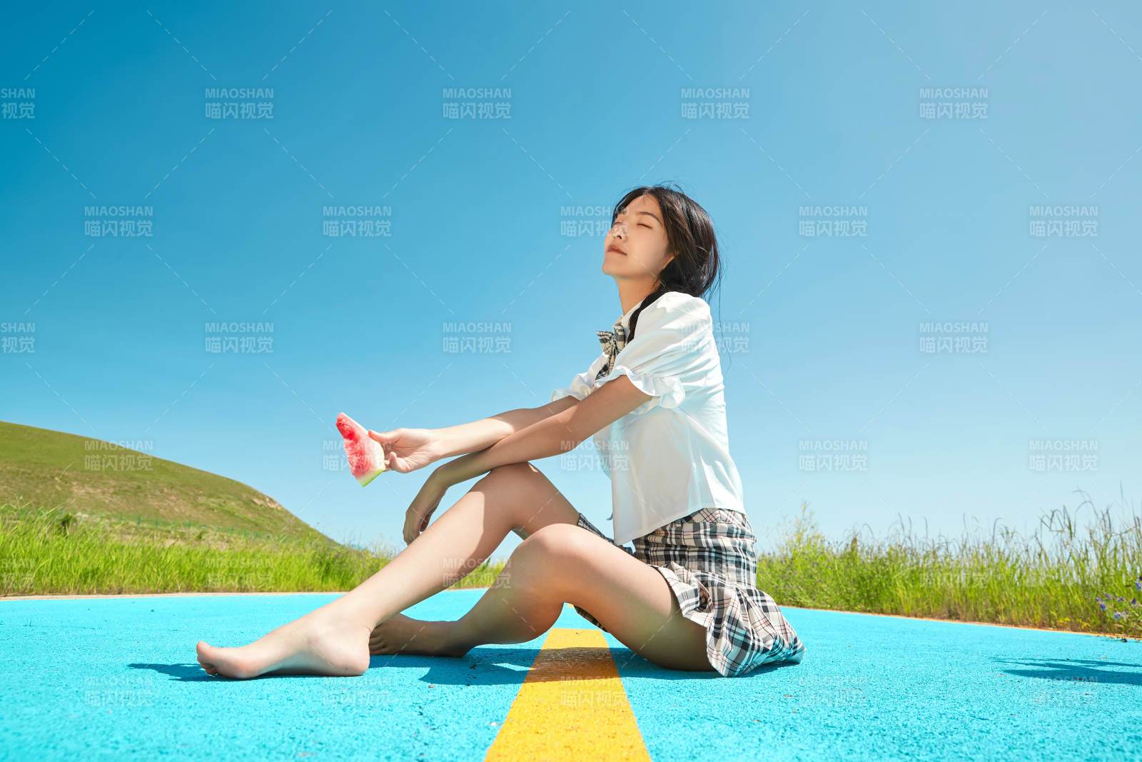 夏日户外湖边彩色公路上玩耍吃西瓜的少女图片