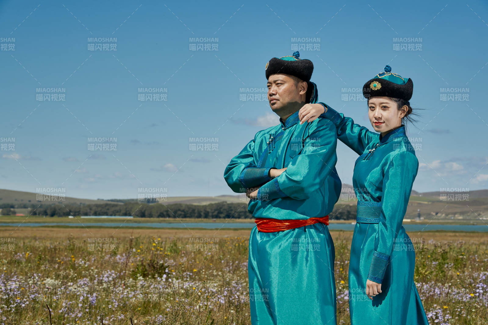 草原上蒙古包前穿蒙古族传统服饰的年轻夫妻图片