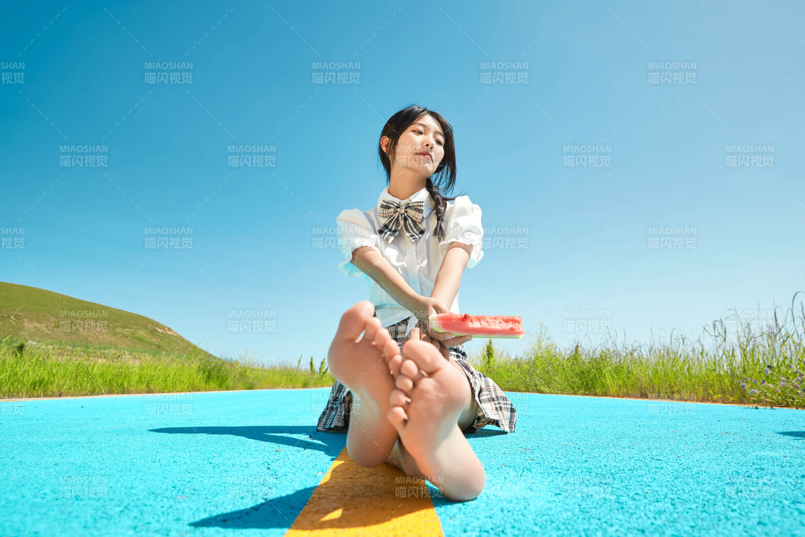 夏日户外湖边彩色公路上玩耍吃西瓜的少女图片