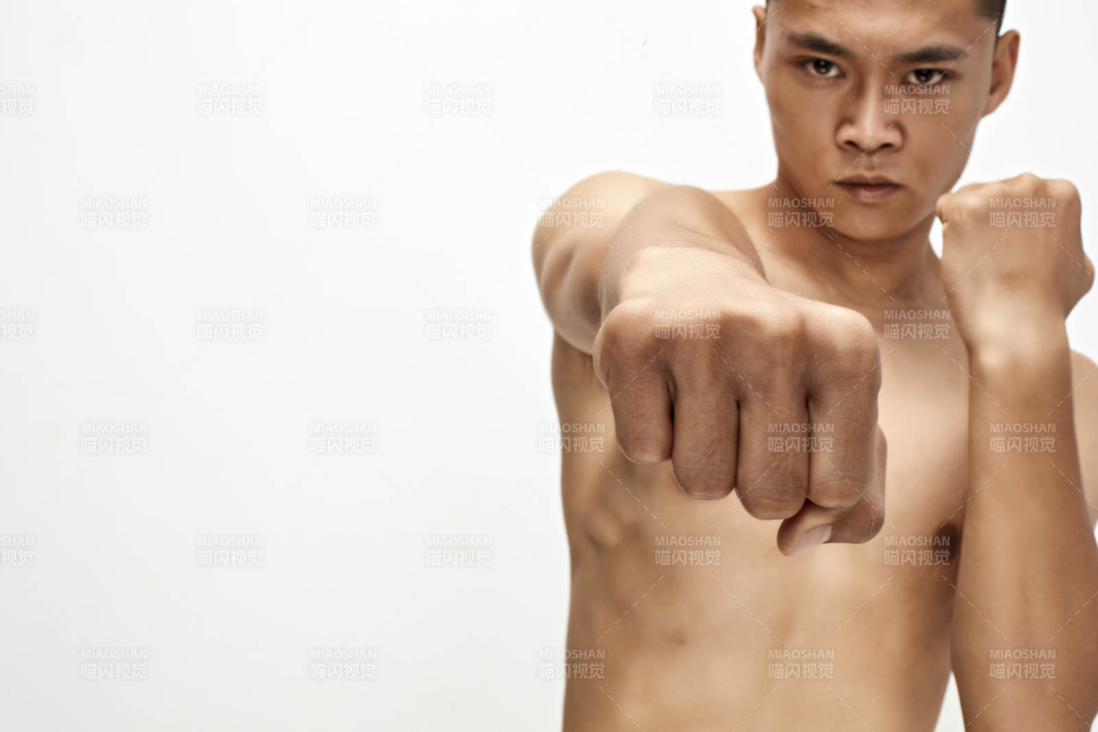 白色背景下演示自由搏击动作的亚洲功夫男性图片