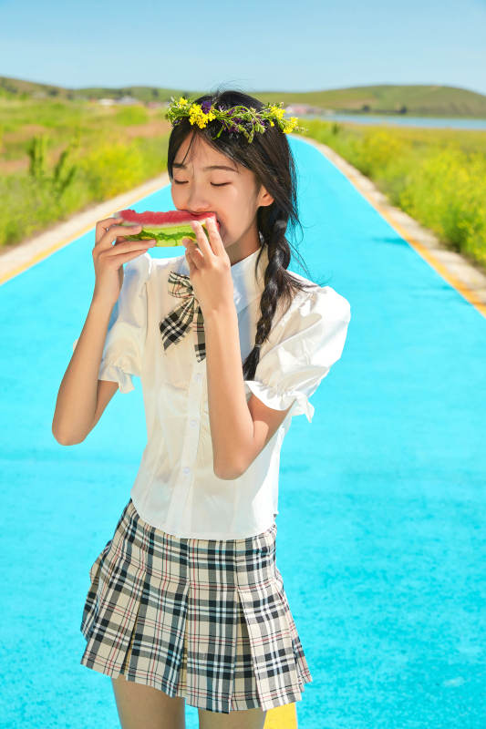 夏日户外湖边彩色公路上玩耍吃西瓜的少女图片